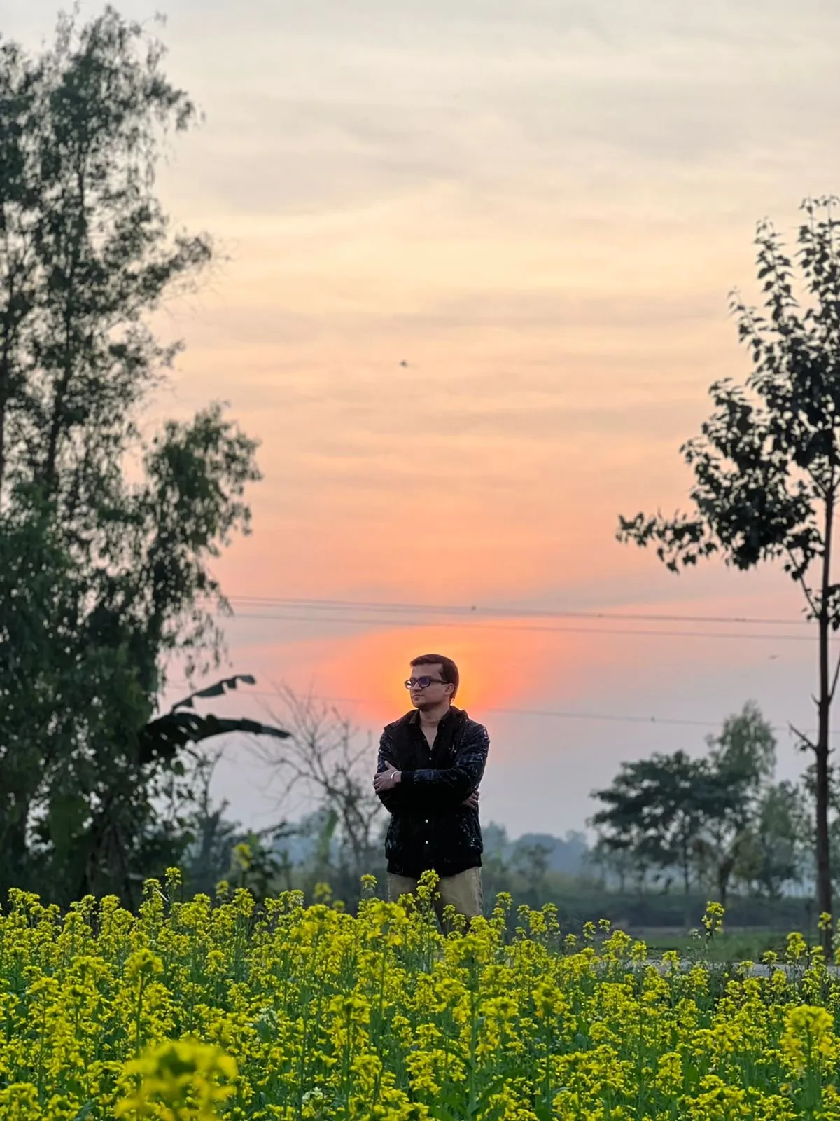 Freelancer Tamal standing in a yellow mustard-flower field at sunset in Rangpur Division, Bangladesh