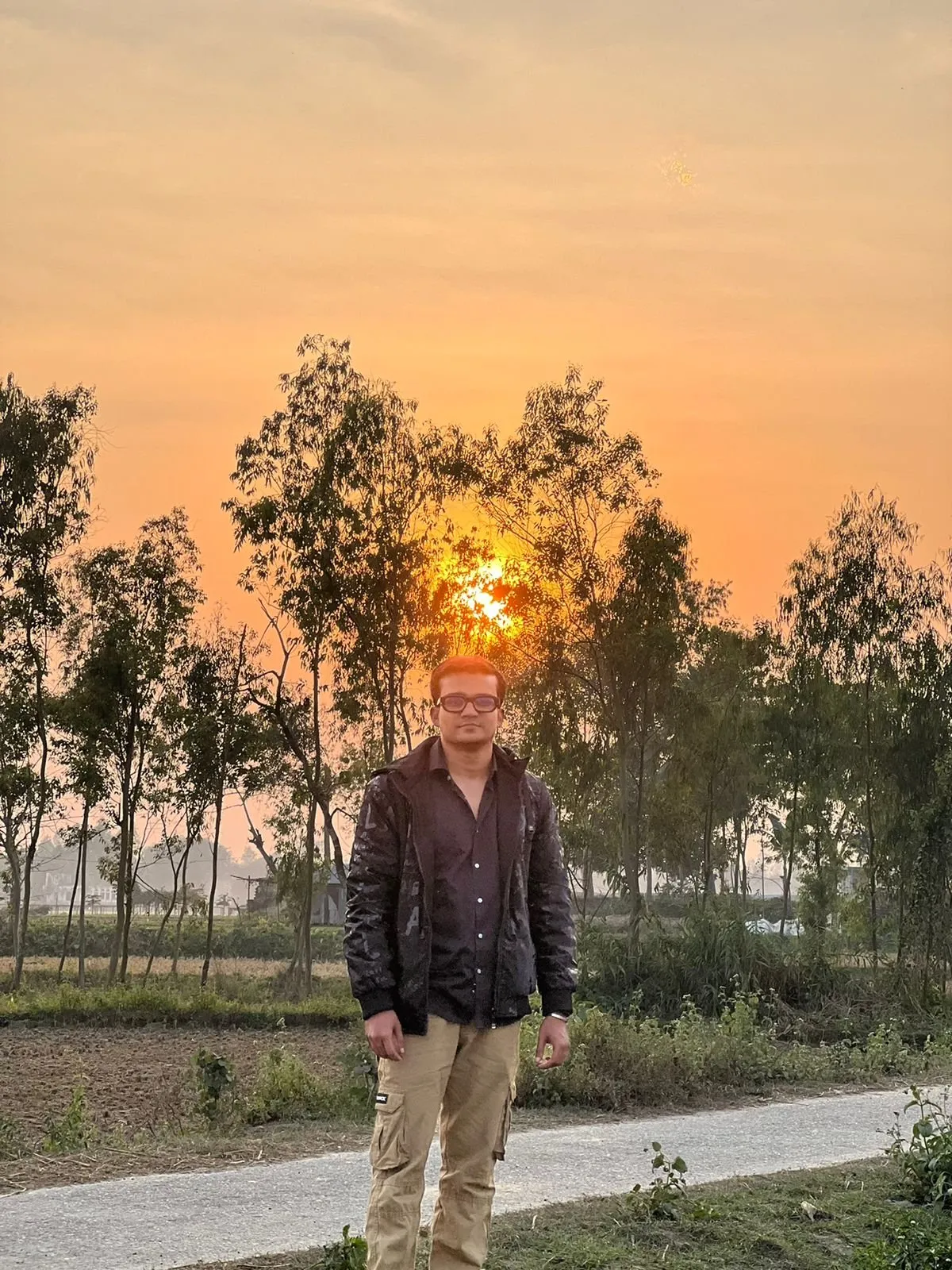 Freelancer Tamal walking at golden hour on a quiet rural road through eucalyptus trees outside Rangpur, Bangladesh